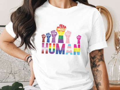 White t-shirt with rainbow pride flag fists and "HUMAN" text.