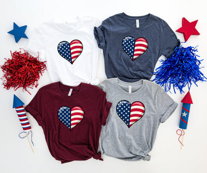 Four t-shirts in white, navy, maroon, and gray, each with an American flag heart design.