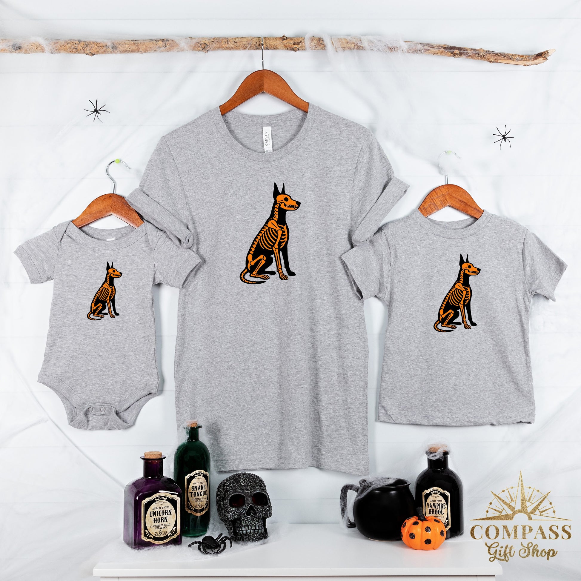 Grey t-shirts and a baby bodysuit feature a skeleton dog graphic.