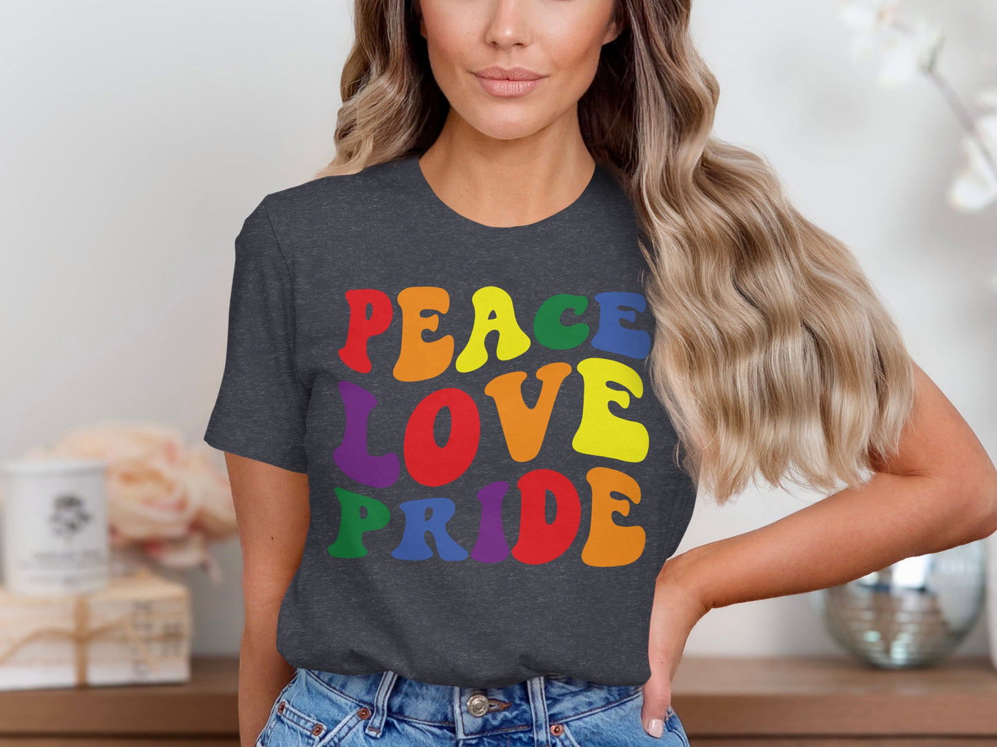 Dark t-shirt with "Peace Love Pride" in rainbow gradient letters.