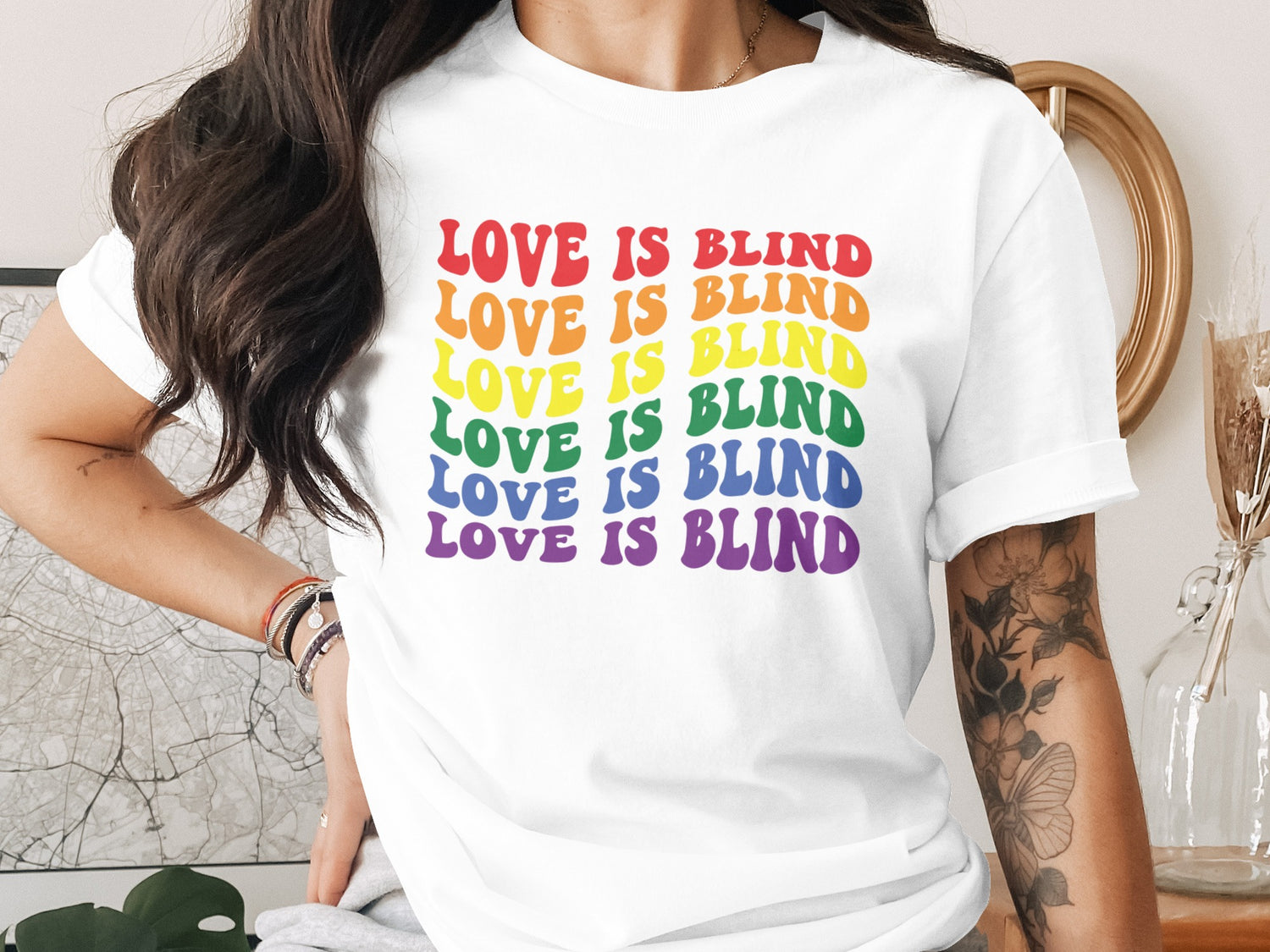 White t-shirt with rainbow "LOVE IS BLIND" text.