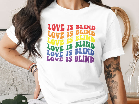 White t-shirt with rainbow "LOVE IS BLIND" text.
