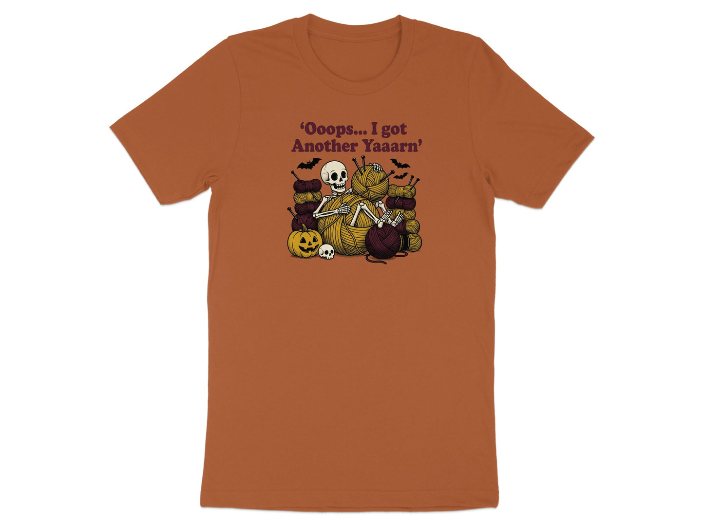 Skeleton surrounded by yarn, knitting needles, pumpkin, and skulls. Text reads: 'Oooops... I got Another Yaaarn'.