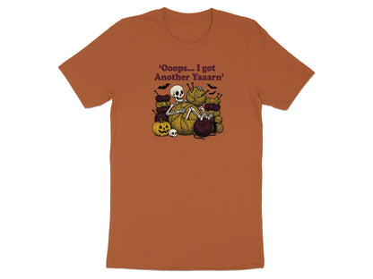 Skeleton surrounded by yarn, knitting needles, pumpkin, and skulls. Text reads: 'Oooops... I got Another Yaaarn'.