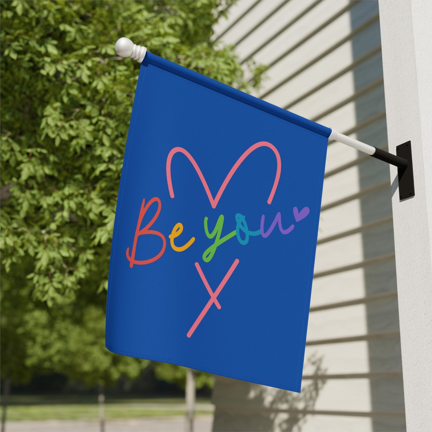 Blue flag with rainbow heart and "Be your" text.