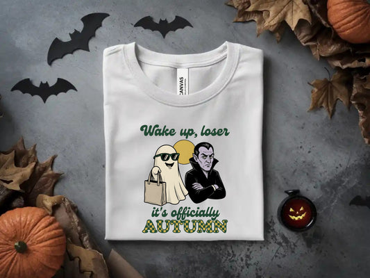 White t-shirt with "Wake up, loser it's officially AUTUMN" and cute ghost and vampire graphics.