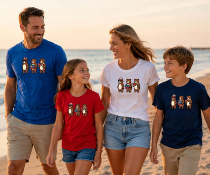 Family of four wearing matching bear t-shirts walking on beach at sunset.