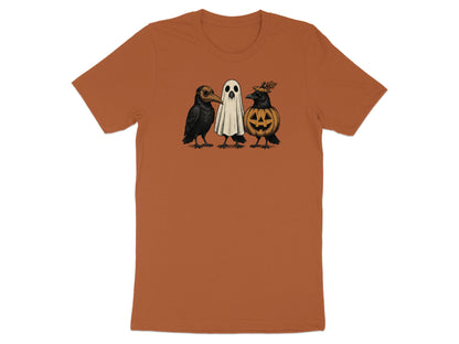 Three Halloween creatures: two crows and a ghost, on a burnt orange t-shirt.