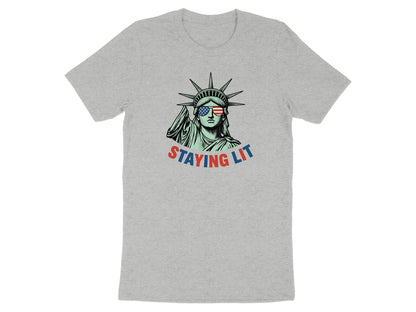 Statue of Liberty wearing sunglasses with American flag lenses, "STAYING LIT" text.