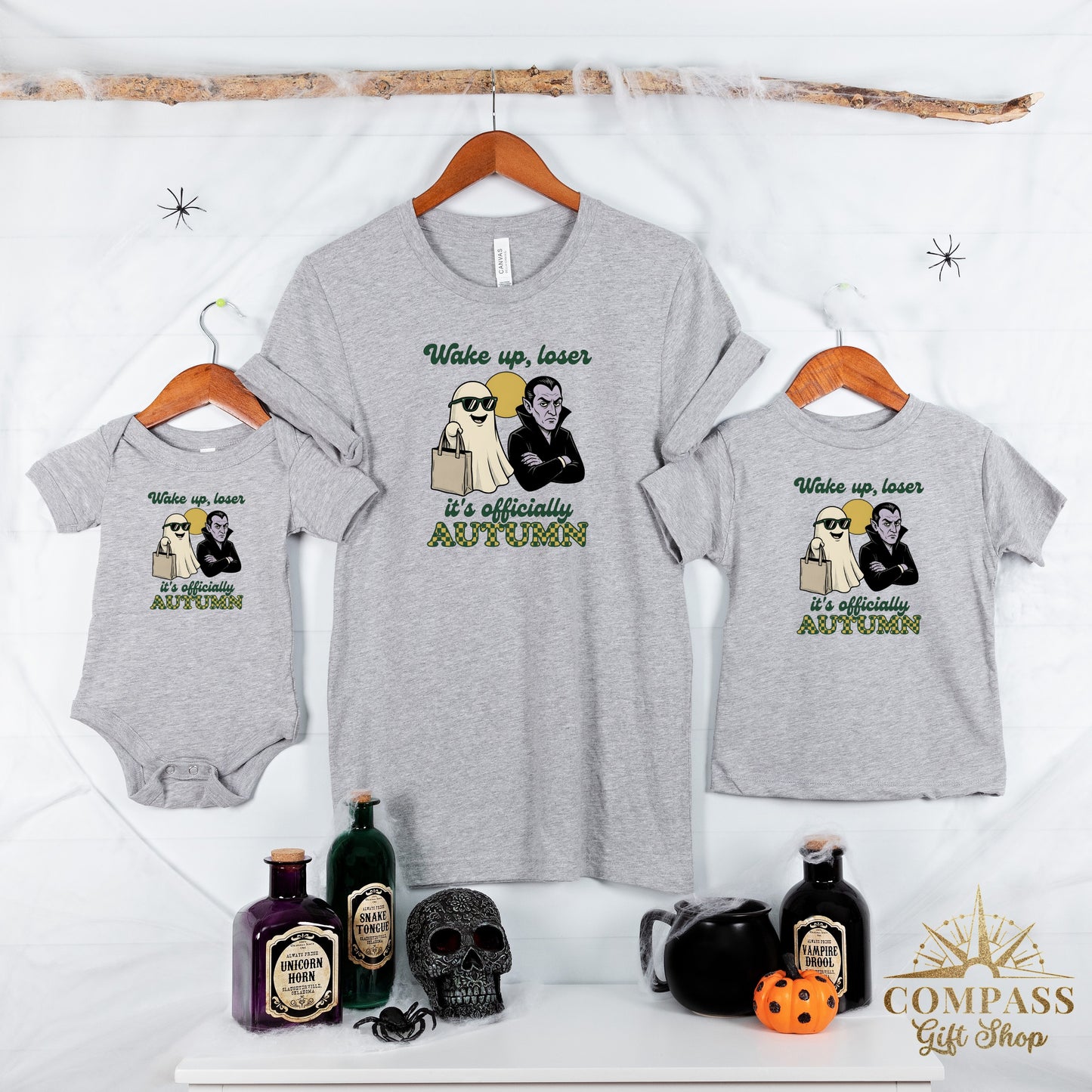 Three grey t-shirts, each with a graphic of a ghost and vampire, and the text "Wake up, loser" and "it's officially AUTUMN."