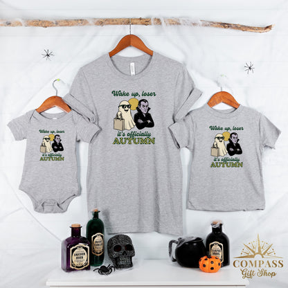 Three grey t-shirts, each with a graphic of a ghost and vampire, and the text "Wake up, loser" and "it's officially AUTUMN."