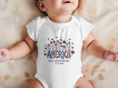 Baby in a white bodysuit with "America 250th Anniversary 1776-2026" and floral design.