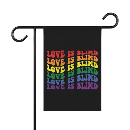Black garden flag with "LOVE IS BLIND" repeated in rainbow colors.