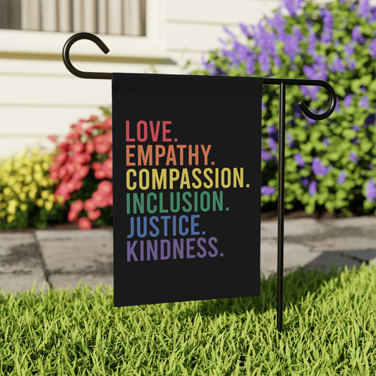 Black garden flag with rainbow text: Love, Empathy, Compassion, Justice, Kindness.