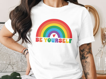 White t-shirt with colorful rainbow and "BE YOURSELF" text.
