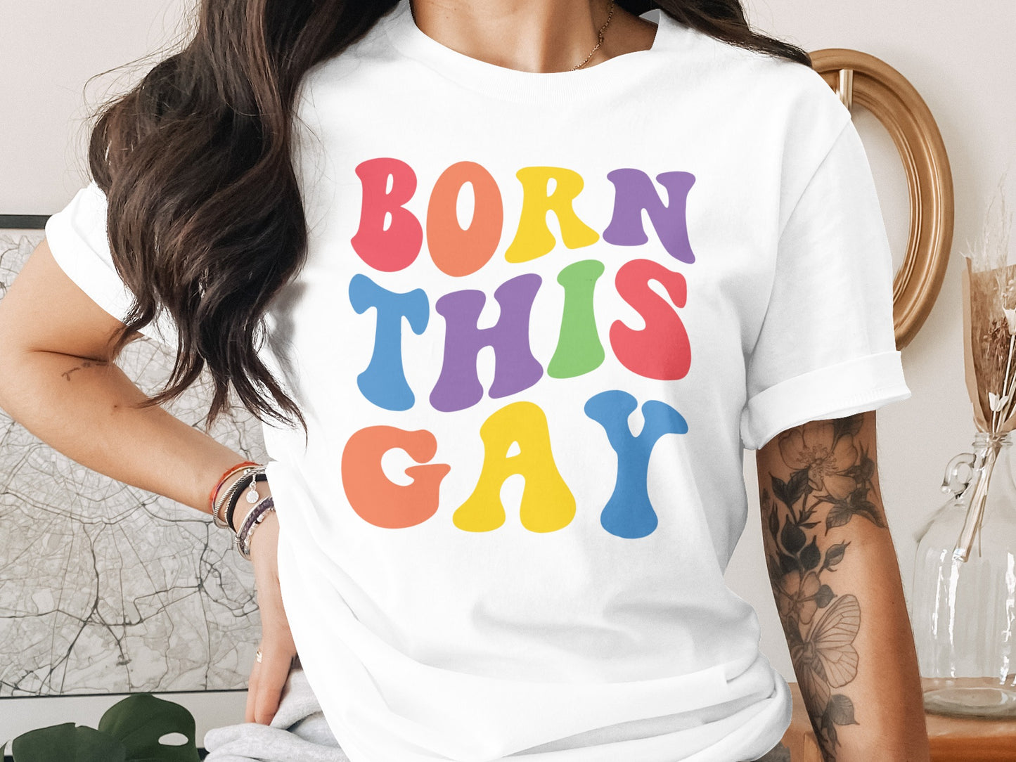 White t-shirt with "BORN THIS GAY" in colorful, wavy letters.