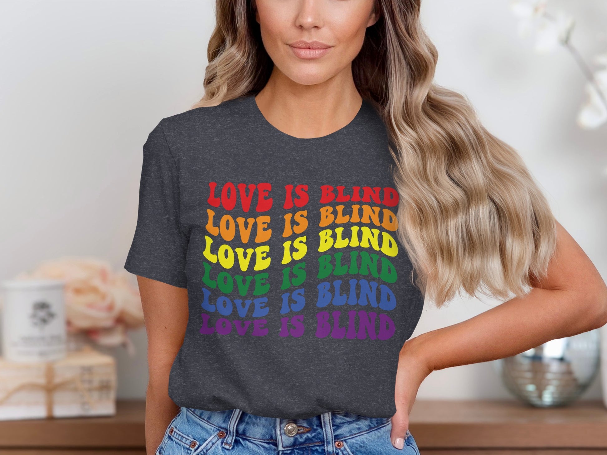 Dark t-shirt with "LOVE IS BLIND" repeated in rainbow colors.