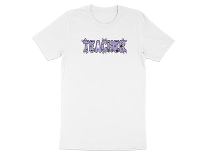 White t-shirt with "TEACHER" text in purple with Halloween-themed embellishments.