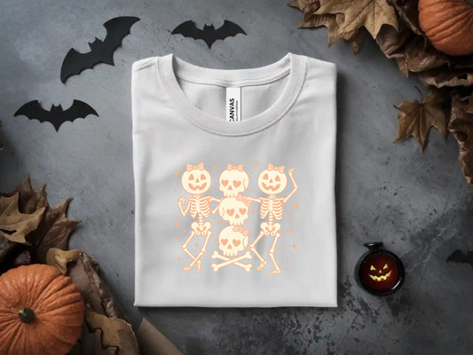 White t-shirt with dancing skeleton graphic, featuring heart eyes and bows, surrounded by Halloween decor.