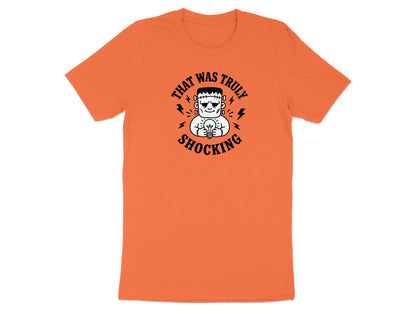 Orange t-shirt featuring Frankenstein holding a lightbulb with text "THAT WAS TRULY SHOCKING".
