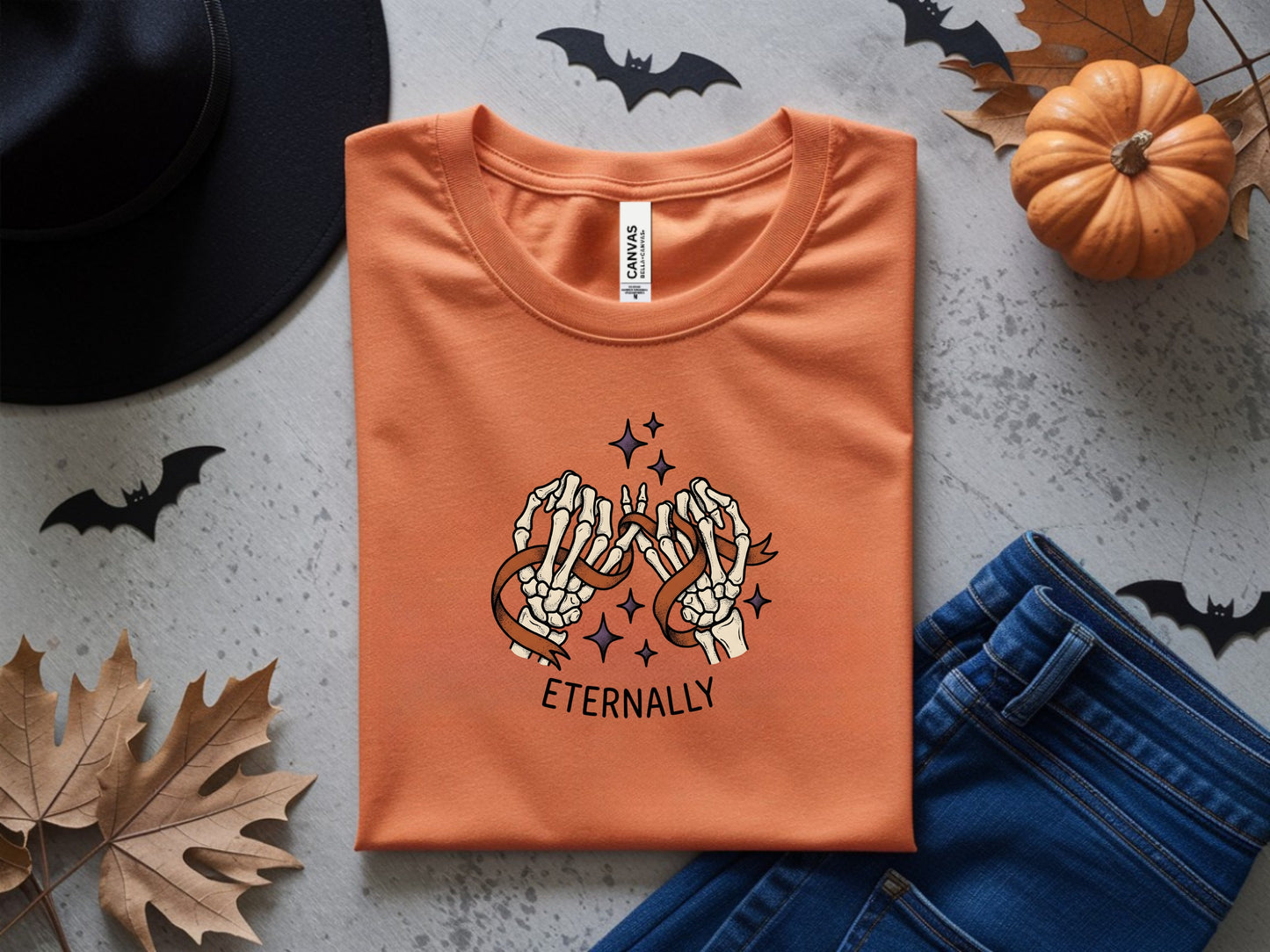 Orange t-shirt with skeleton hands and ribbon design that reads "eternally".
