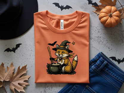 Orange t-shirt with a witch fox and cauldron Halloween design.