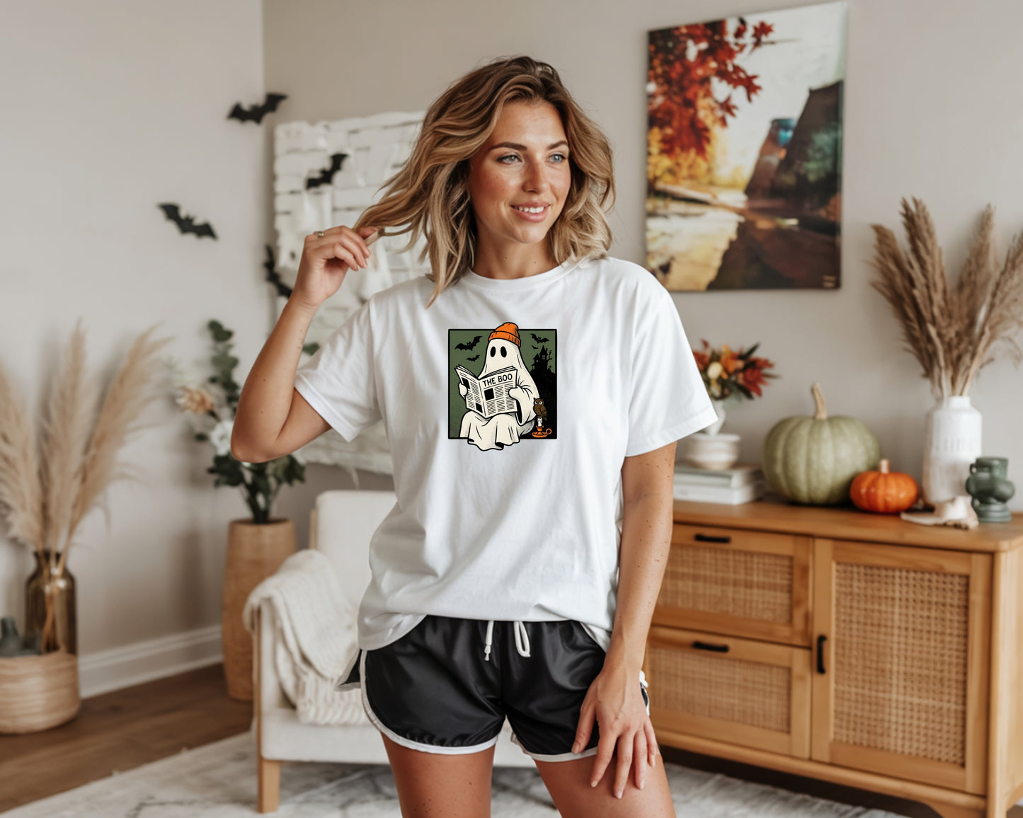 White t-shirt with a graphic of a ghost reading a newspaper titled "The Boo".