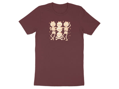 Three dancing skeletons with bow details and crossed bones on a maroon t-shirt.