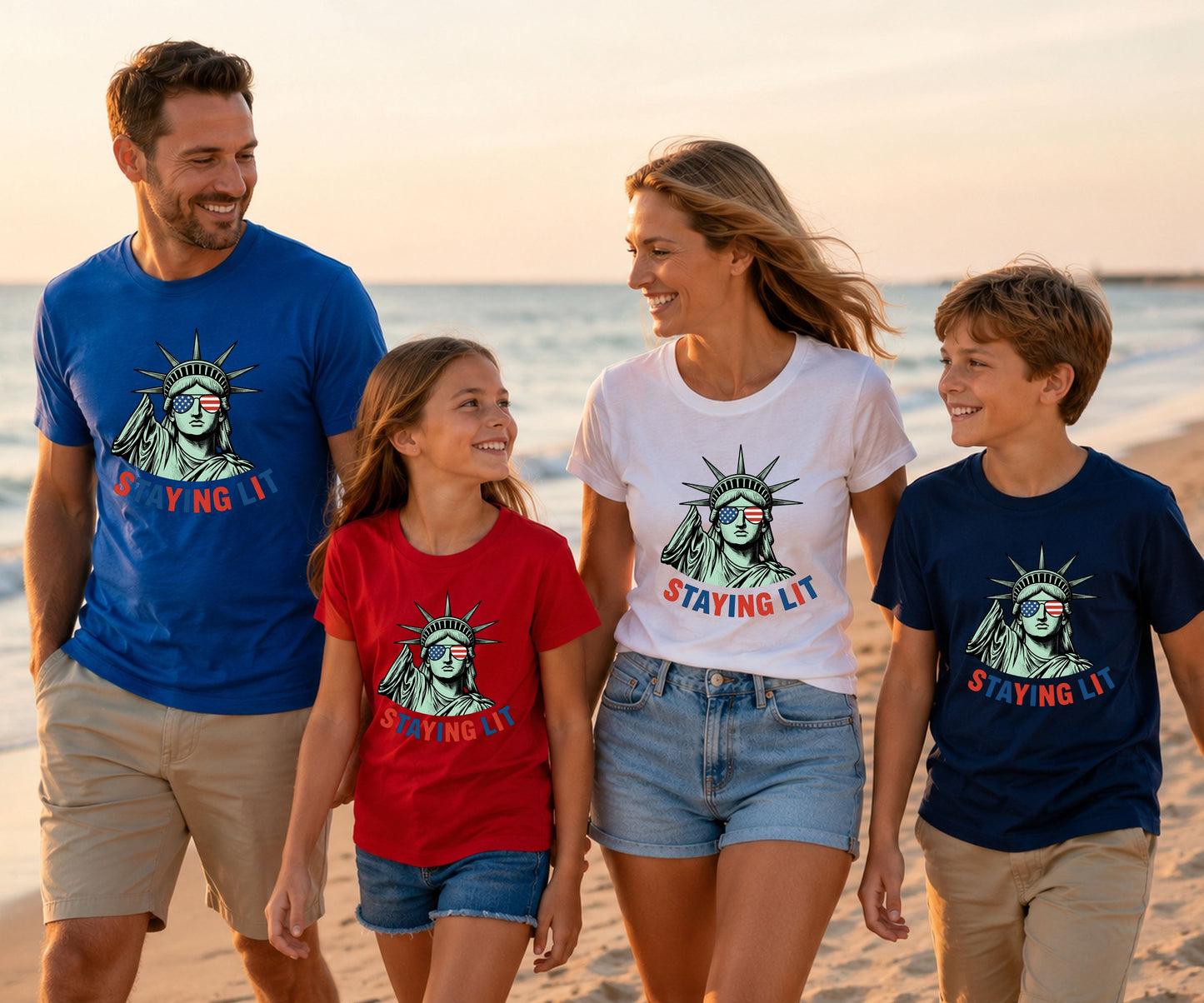 Family wearing matching "STAYING LIT" graphic tees on a beach.