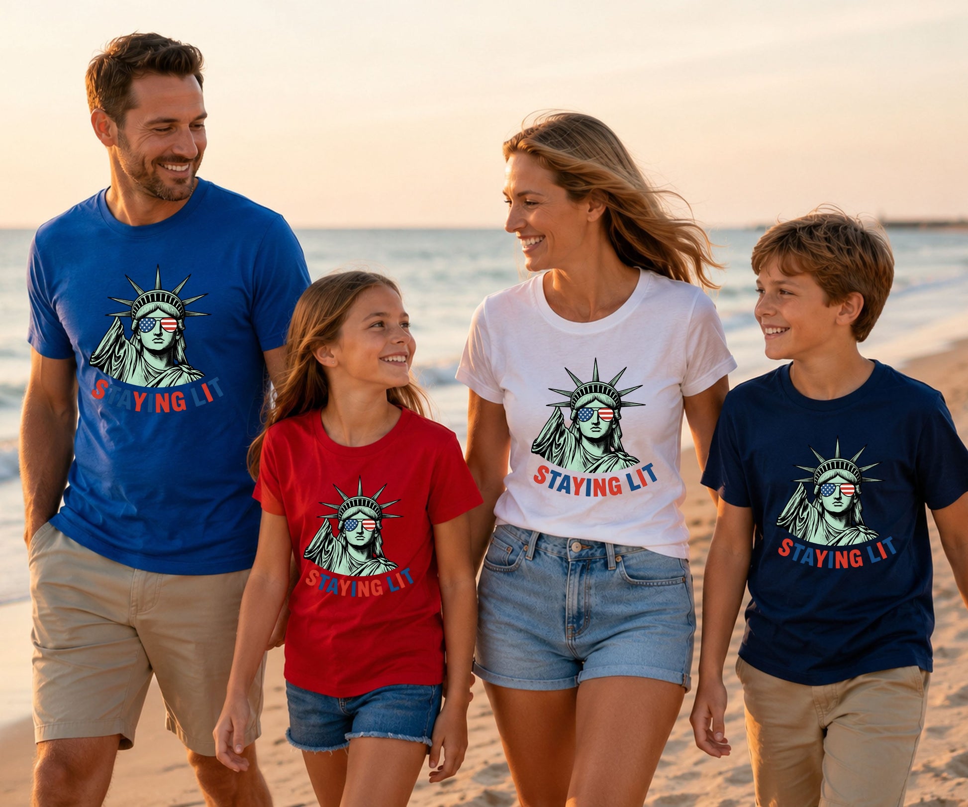Family wearing matching "STAYING LIT" graphic tees on a beach.
