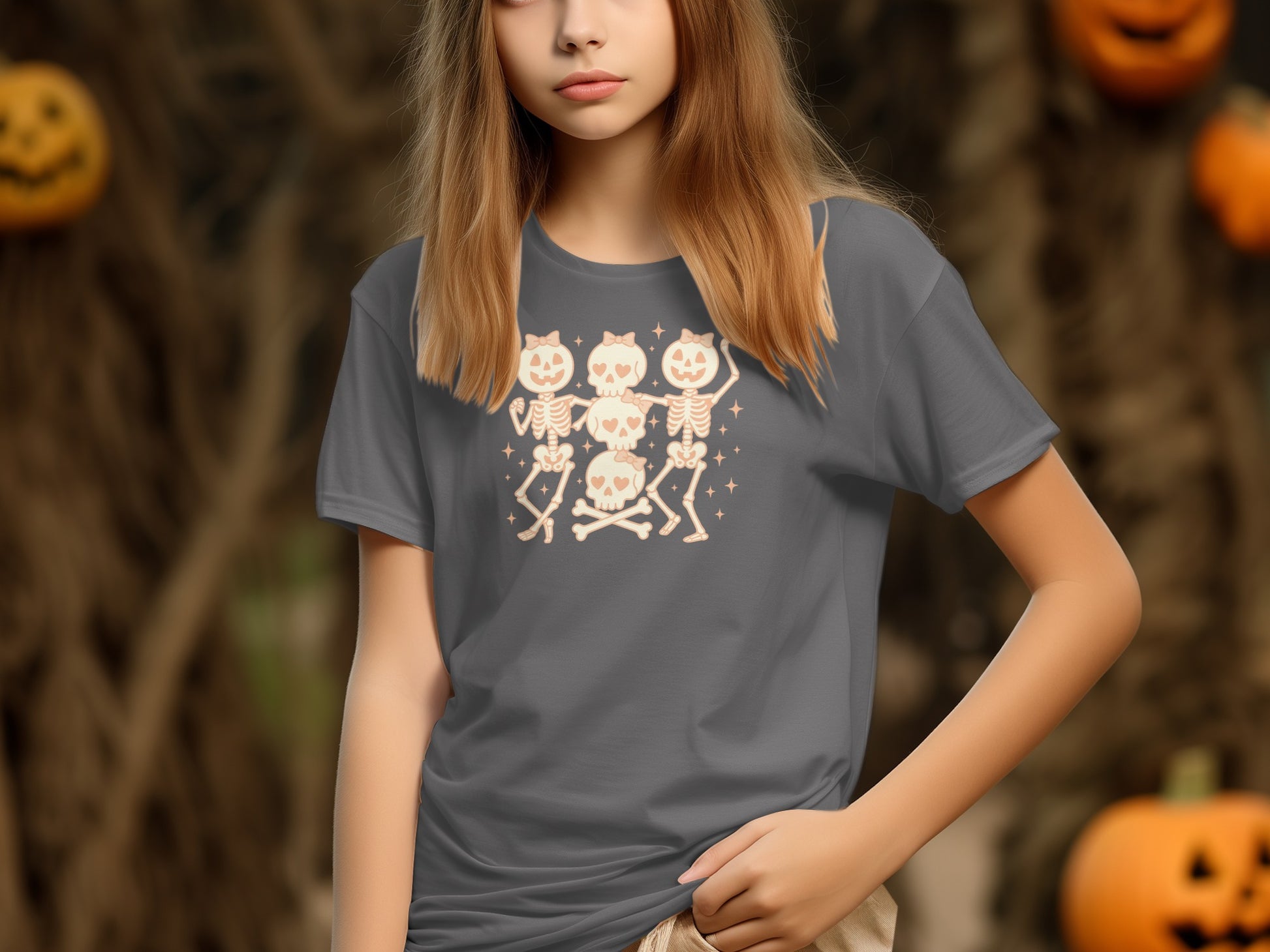 Gray t-shirt with dancing skeletons and skulls graphic, with pumpkins in background.