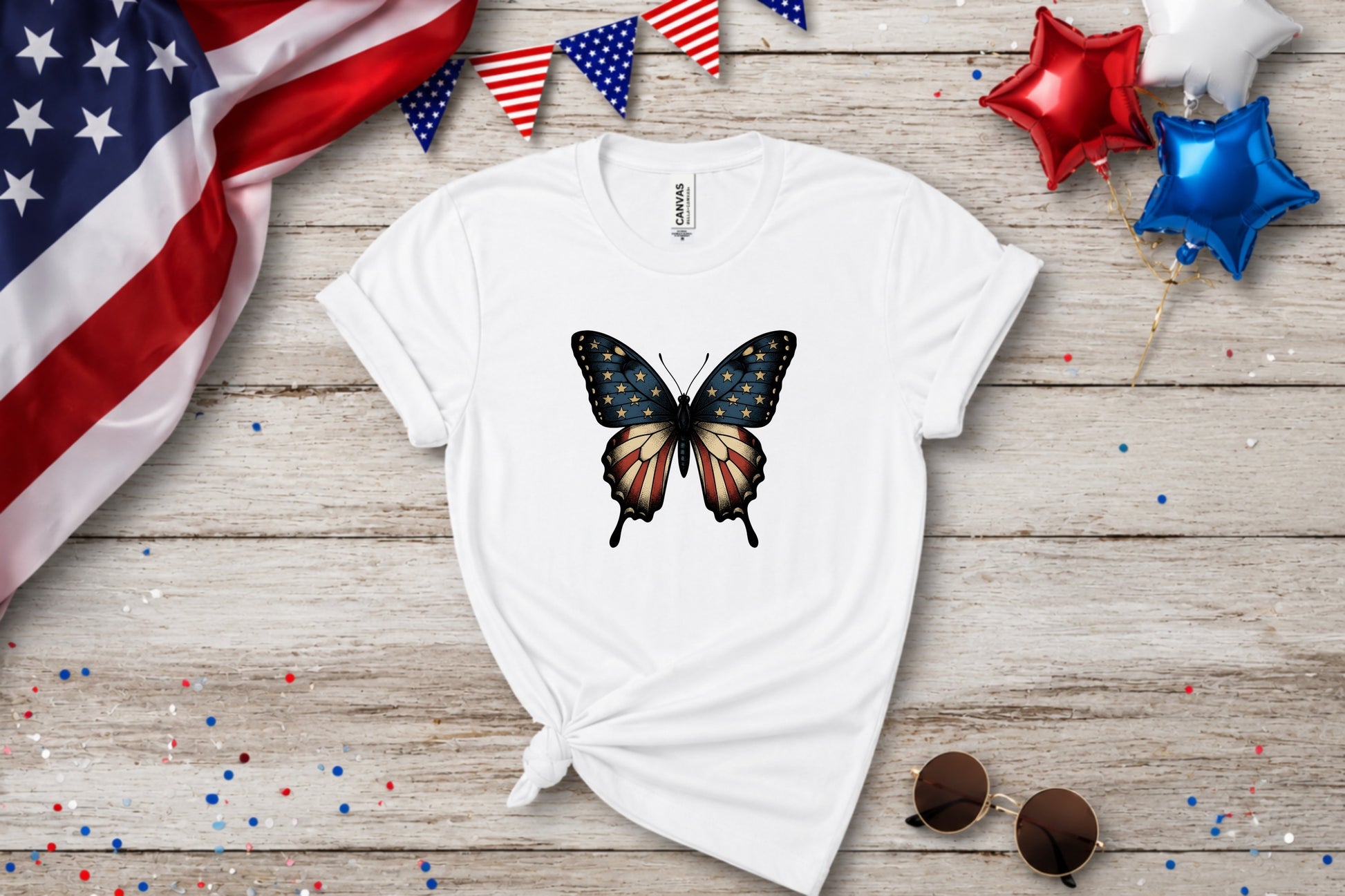 White t-shirt with distressed American flag butterfly graphic, patriotic bunting and balloons.