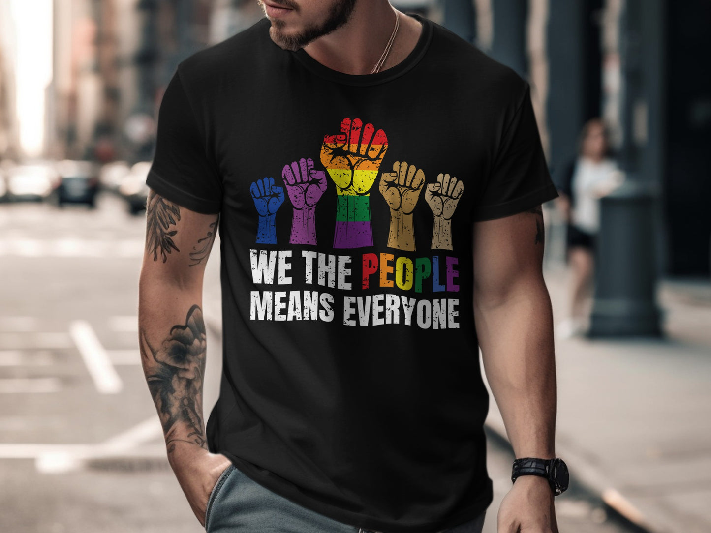 Black t-shirt with rainbow fists and "WE THE PEOPLE MEANS EVERYONE" text.