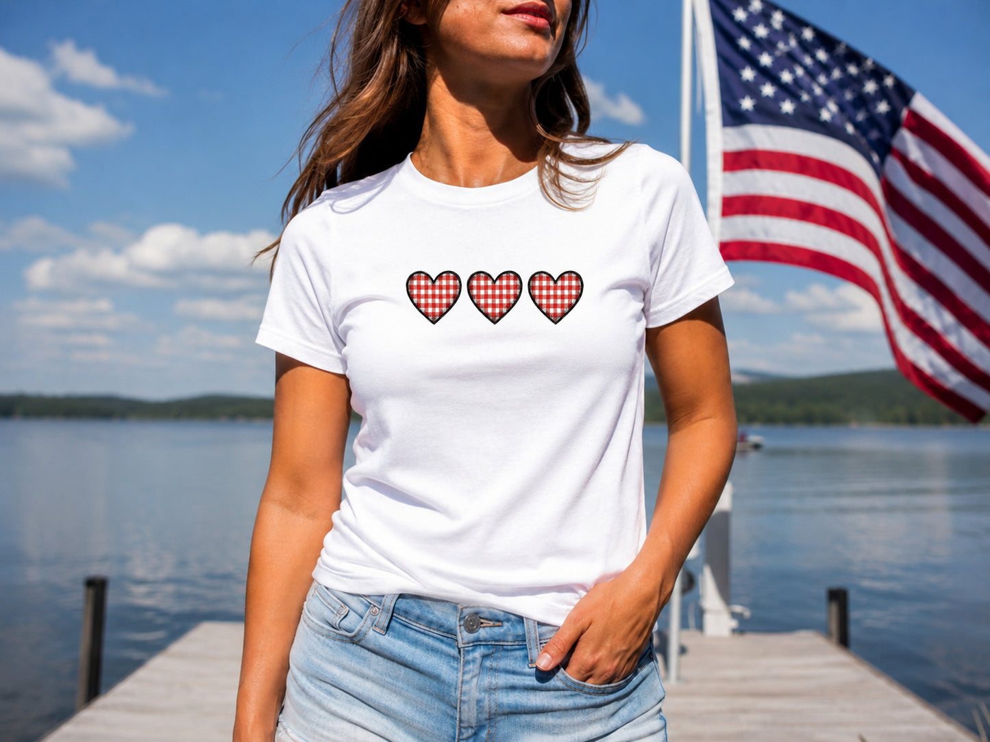 White t-shirt with three red and black buffalo plaid hearts.