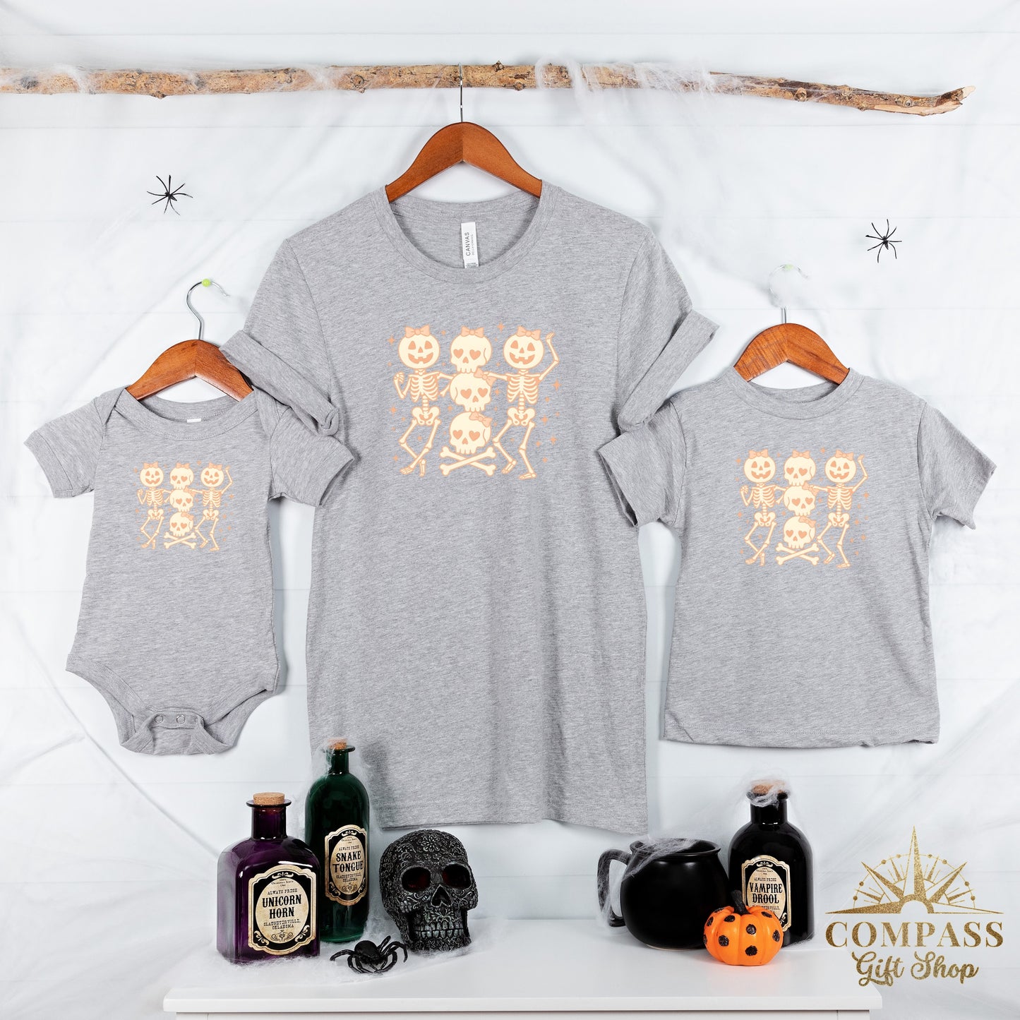 Grey t-shirts and baby onesie with cartoon skeletons and Halloween potions.