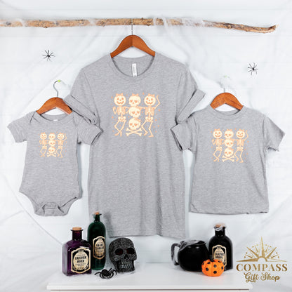 Grey t-shirts and baby onesie with cartoon skeletons and Halloween potions.