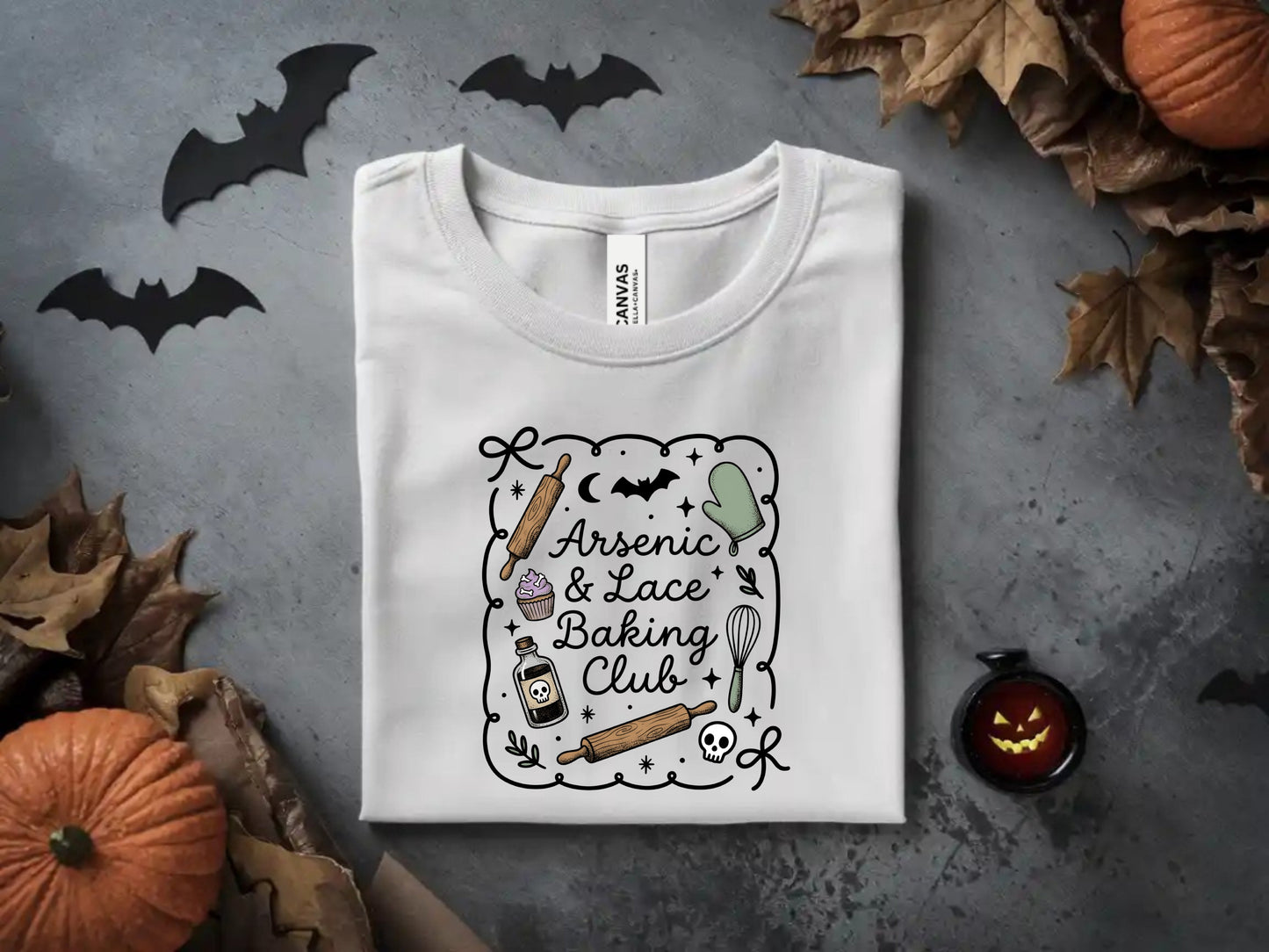 White t-shirt with "Arsenic & Lace Baking Club" Halloween-themed graphic.