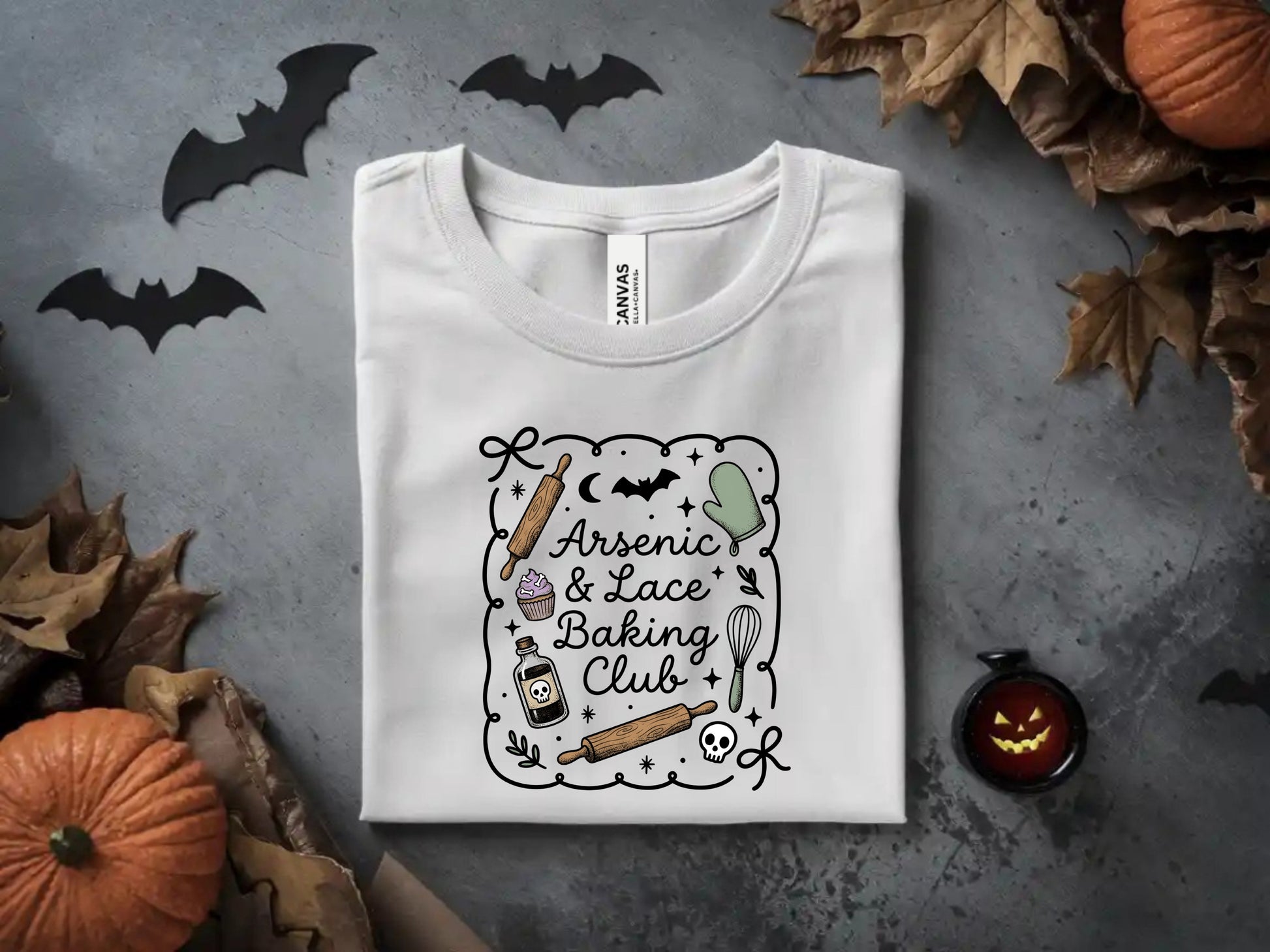 White t-shirt with "Arsenic & Lace Baking Club" Halloween-themed graphic.