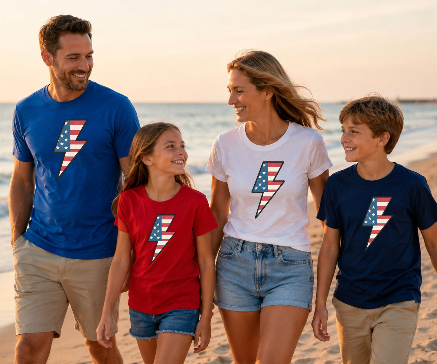Family in matching shirts with American flag lightning bolt design on beach.