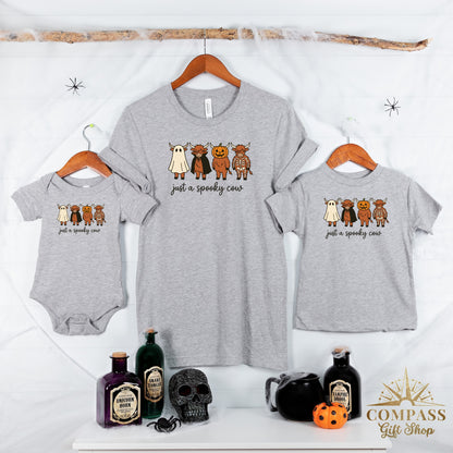 Grey shirts and a onesie with cartoon cows dressed as ghosts, vampires, pumpkins, and skeletons.