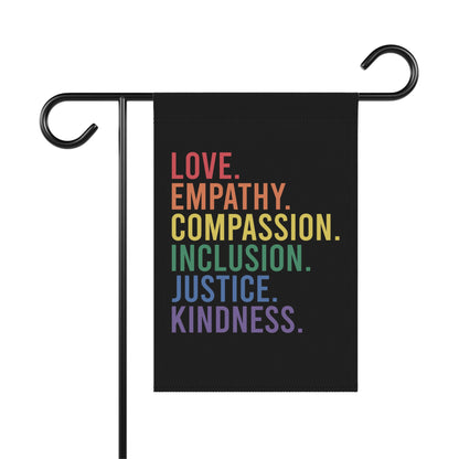 Black garden flag with rainbow text: Love, Empathy, Compassion, Inclusion, Justice, Kindness.
