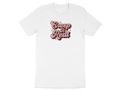 White t-shirt with pink "Creep It Real" text and small star accents.