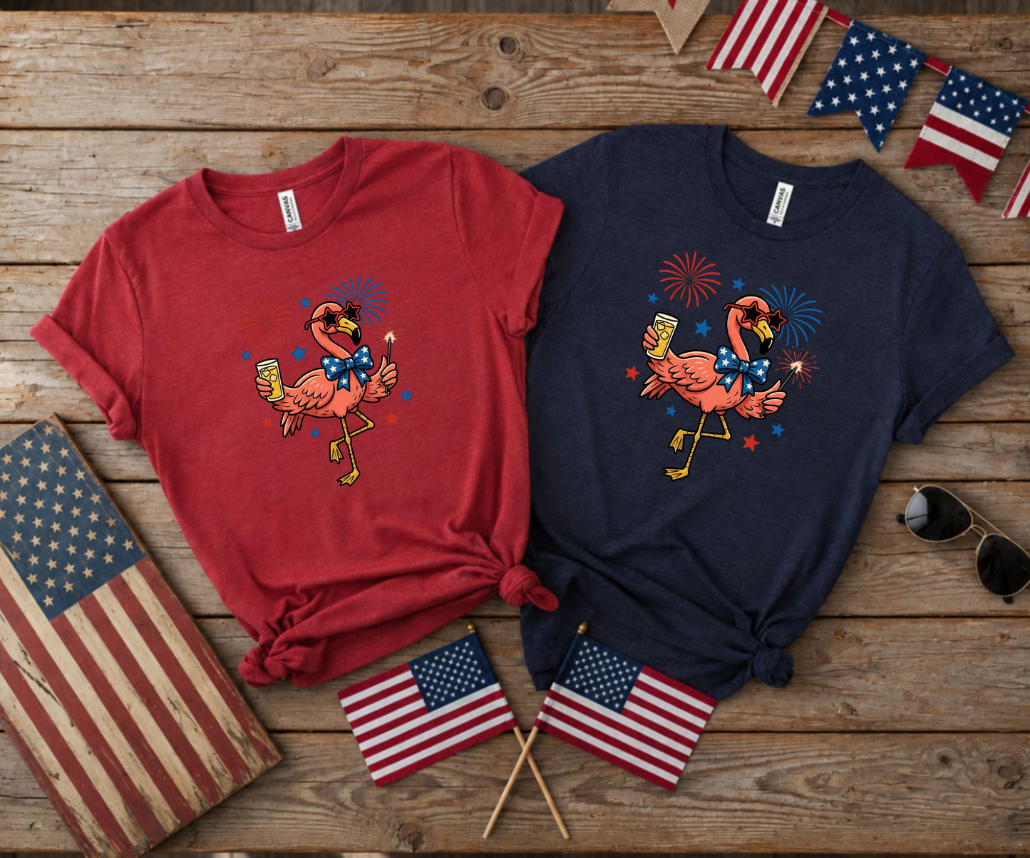 Flamingos in patriotic shirts holding sparklers with American flags and sunglasses.