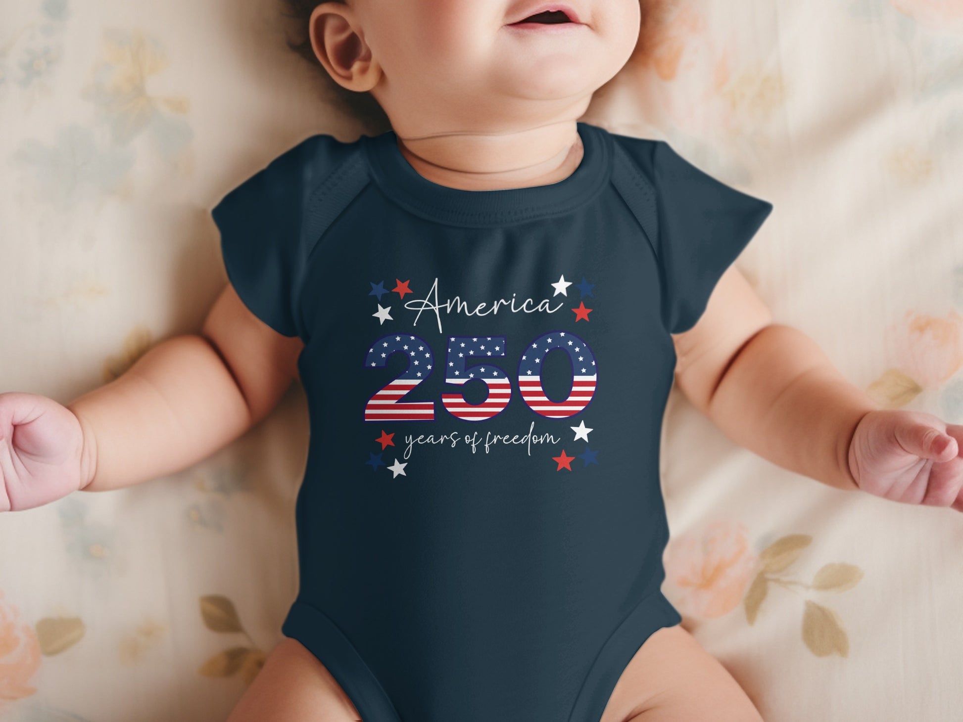 Navy baby bodysuit with "America 250 years of freedom" and stars.