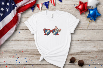 White t-shirt with patriotic heart sunglasses and bow graphic.