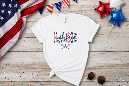 White t-shirt with "Lake American" in red, white, and blue lettering and crossed oars.