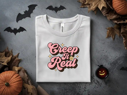 White t-shirt with pink and brown text that says "Creep It Real"