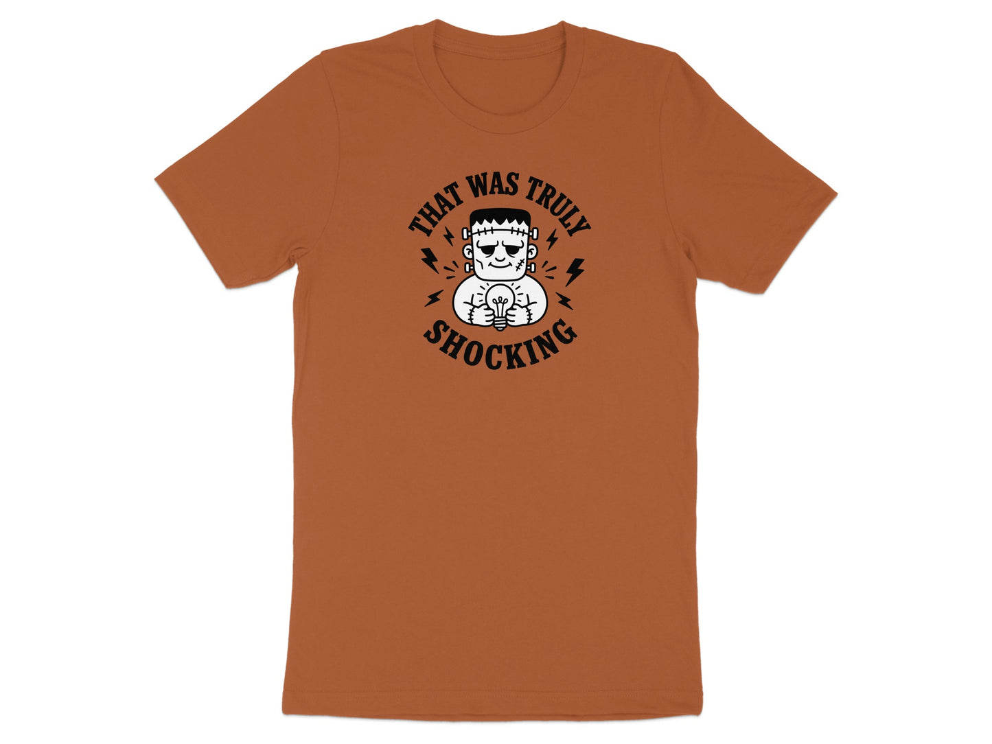 Frankenstein monster holding a lightbulb on an orange t-shirt with "That Was Truly Shocking" text.