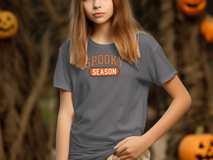 Gray t-shirt with "SPOOKY SEASON" text, against a Halloween backdrop.