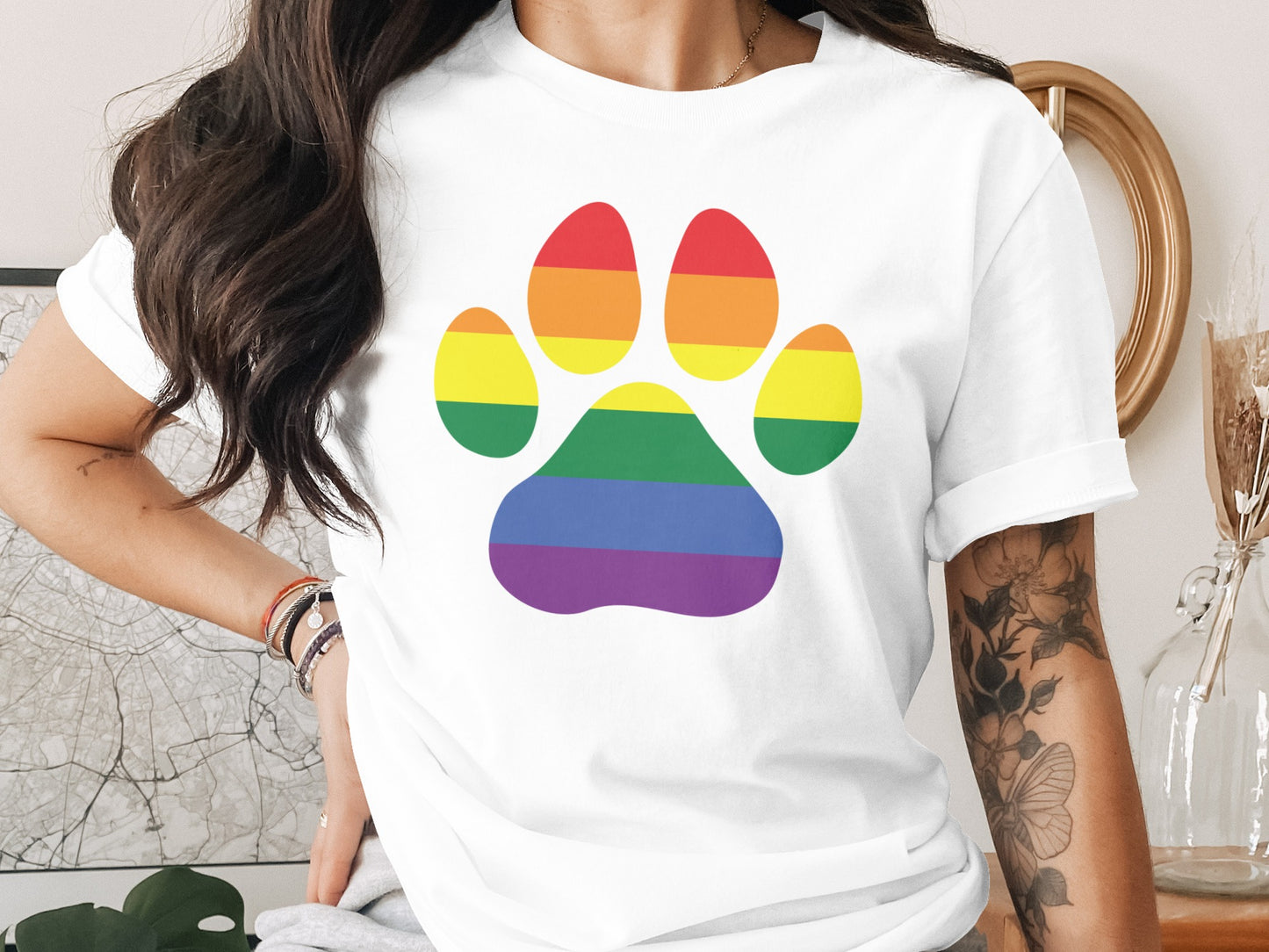 White t-shirt with a rainbow paw print design.